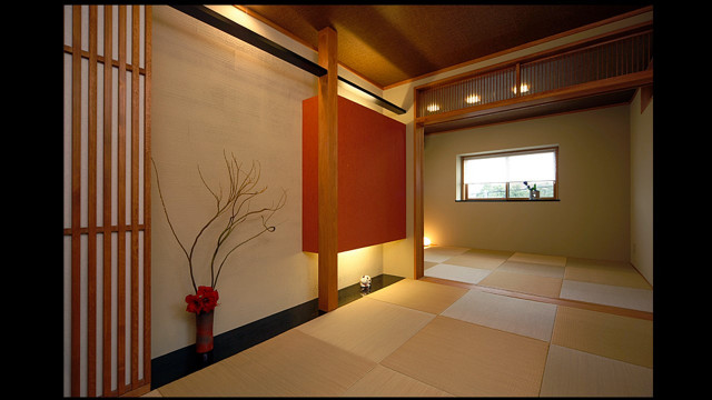 木造２階建て・二世帯住宅への耐震改修フルリノベーション： 洋室６帖の二部屋の構造補強をして壁を抜いてモダン和風なゲストルームに。床の間と吊り押入れ・縦格子の収納にデザインを施しました。
