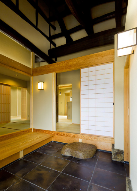 上屋根の丸太梁を現しにした玄関取次。良質の素材が受け継がれる古民家ならではの空間。