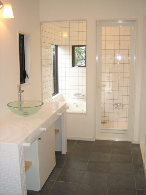 キッチンと統一感のあるトイレ・バスルーム 広い洗面台は収納力も備えています。