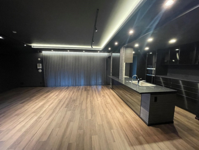 マンションにて内装全改修を行いました。写真はリビングルームです。壁・天井は黒やグレー系を、床には明るめの色を採用したことで、豪華なライブハウスのようなおしゃれで華々しい雰囲気の内装に仕上がりました。