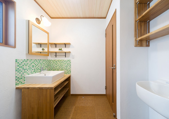 洗面所のリフォーム ： 無垢板のカウンター、周りはモザイクタイル張りとおしゃれな洗面台。また、湿気の多い洗面所はカビが発生しやすいので、壁に珪藻土、天井は桧羽目板仕上げです。