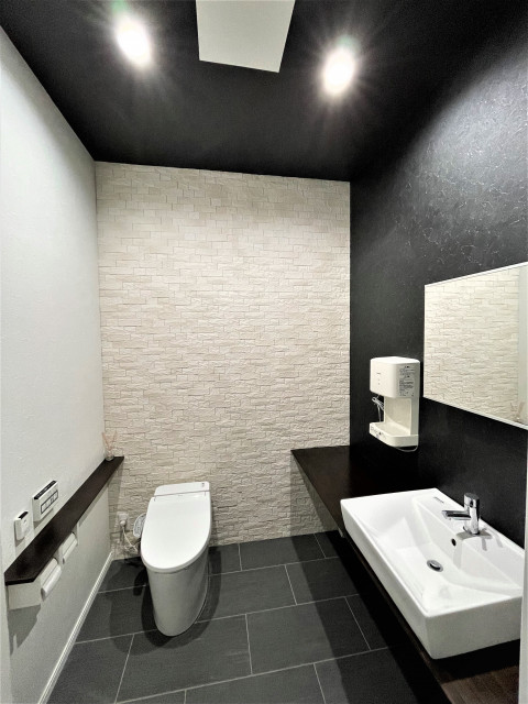 手洗い器付きの洋式トイレです。床壁共にお取替えし、モダンでおしゃれなパウダールームに生まれ変わりました。