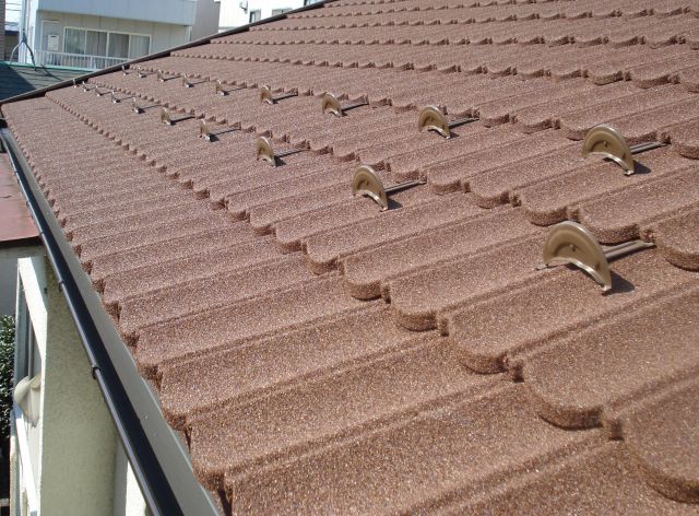瓦から金属石付きの屋根材への葺替え。天然の小石を金属屋根材の表面に吹付けることにより金属屋根のウイｰクポイントである雨音や暑さ寒さを緩和します。屋根材下に空気層がある形状の為湿気対策にも優れています。