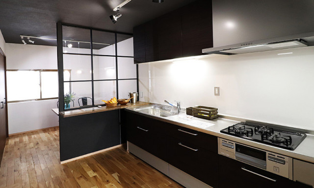 お部屋の中心にあるキッチンは、ブラックでかっこよく。 アイアン造作のパーテーションには木製の棚を設置。 ちょっとした棚が便利です。