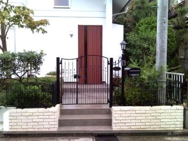 【外構工事】外壁用の白タイルを利用し、明るく開放的な雰囲気にしました。塀を低くし、門扉を大きくしたことで南欧風の門扉・フェンスをセレクトしたことで高級感漂う門構えとなりました。